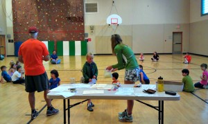 Eva and Glenn hand out participation certificates to the Paxon Elementary kids' running club.