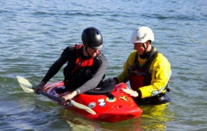 Jason Shreder teaches a kayaker how to roll.